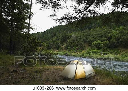 Stock Photograph - Tent and campsite by river. Fotosearch