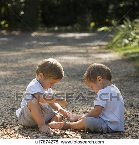 Stock Photography - Toddler boys playing with pebbles. Fotosearch