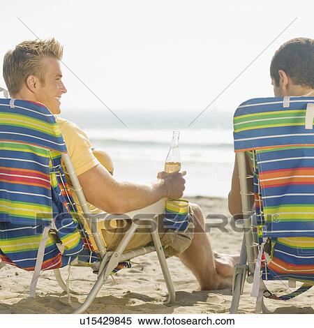 Stock Photography - Two men sitting in beach chairs. Fotosearch