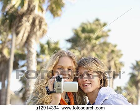 Picture - Two women looking at video camera. Fotosearch