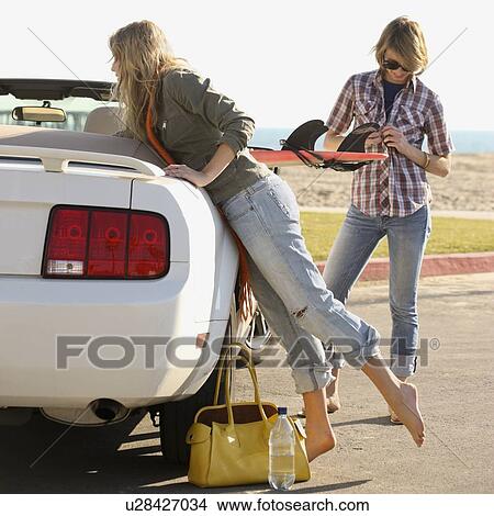 Two women next to convertible at beach View Large Photo Image Picture - Two women next to convertible at beach. Fotosearch