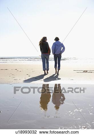Two women walking on beach View Large Photo Image Stock Image - Two women walking on beach. Fotosearch