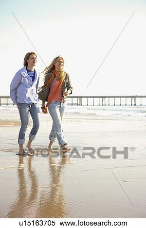 Stock Photography - Two women walking on beach. Fotosearch