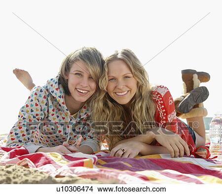 Two young women laying on beach View Large Photo Image Picture - Two young women laying on beach. Fotosearch