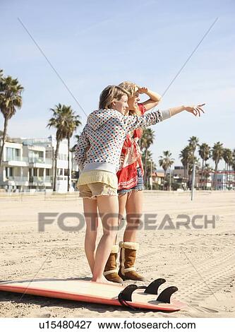 Stock Photo - Two young women standing on beach. Fotosearch
