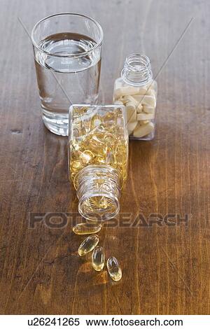 Stock Photography - Vitamins in bottles next to water. Fotosearch