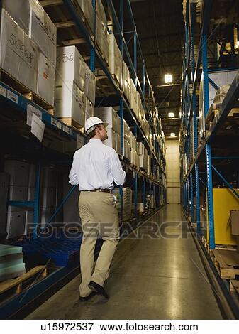 Warehouse worker checking inventory View Large Photo Image Stock Photo - Warehouse worker checking inventory. Fotosearch