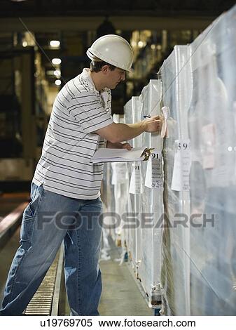 Stock Photography - Warehouse worker checking shipments. Fotosearch
