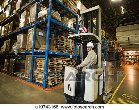 Warehouse worker driving forklift View Large Photo Image Stock Photograph - Warehouse worker driving forklift. Fotosearch
