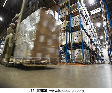 Stock Photography - Warehouse worker driving forklift with palette. Fotosearch