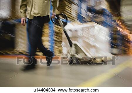 Picture - Warehouse worker pulling palette. Fotosearch