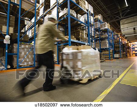 Warehouse worker pushing palette View Large Photo Image Stock Photo - Warehouse worker pushing palette. Fotosearch