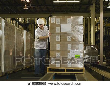 Warehouse worker pushing palette View Large Photo Image Stock Photography - Warehouse worker pushing palette. Fotosearch
