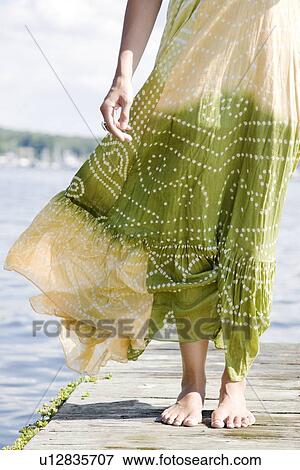 Wind blowing dress of woman standing on dock View Large Photo Image Stock Photo - Wind blowing dress of woman standing on dock. Fotosearch