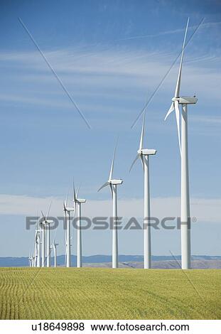 Windmills in a row on wind farm View Large Photo Image Stock Photo - Windmills in a row on wind farm. Fotosearch