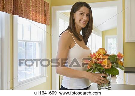 Woman arranging flowers at home View Large Photo Image Stock Photo - Woman arranging flowers at home. Fotosearch