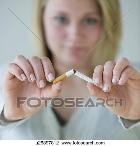 Stock Image - Woman breaking cigarette. Fotosearch