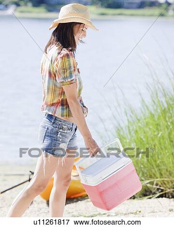 Woman carrying ice chest on beach View Large Photo Image Stock Photo - Woman carrying ice chest on beach. Fotosearch