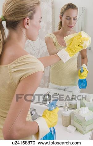 Woman cleaning mirror in bathroom View Large Photo Image Stock Image - Woman cleaning mirror in bathroom. Fotosearch