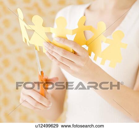 Woman cutting out paper dolls View Large Photo Image Stock Photo - Woman cutting out paper dolls. Fotosearch