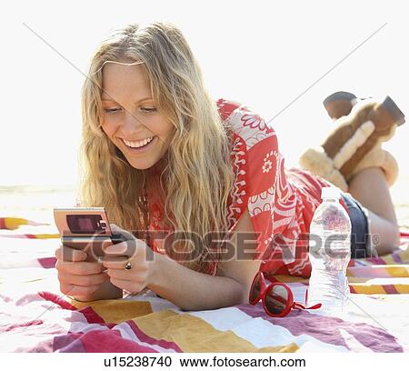 Stock Image - Woman dialing cell phone. Fotosearch