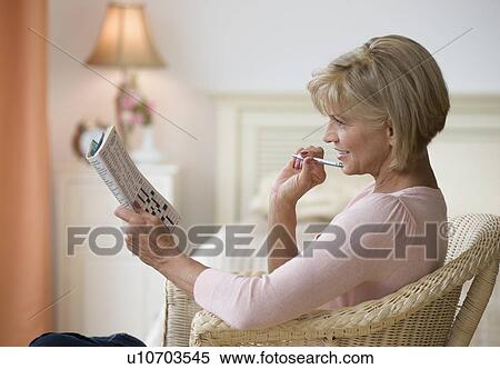 Stock Photography - Woman doing crossword puzzle. Fotosearch