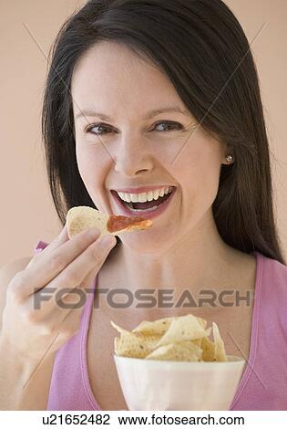 Woman eating chips and dip View Large Photo Image Stock Image - Woman eating chips and dip. Fotosearch