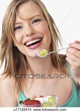 Picture - Woman eating fruit salad. Fotosearch