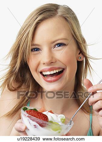 Stock Photo - Woman eating fruit salad. Fotosearch