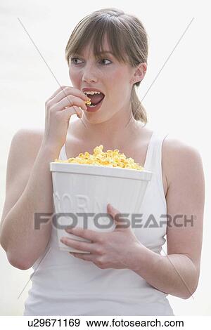 Stock Photo - Woman eating popcorn. Fotosearch