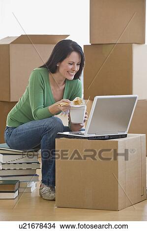 Woman eating take out food in new house View Large Photo Image Picture - Woman eating take out food in new house. Fotosearch