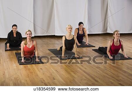 Stock Photo - Woman exercising in yoga class. Fotosearch