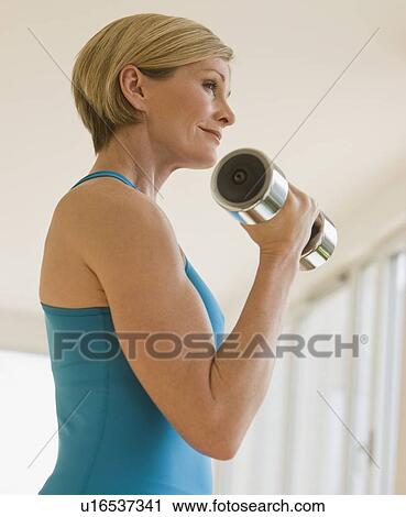 Woman exercising with dumbbell View Large Photo Image Stock Image - Woman exercising with dumbbell. Fotosearch