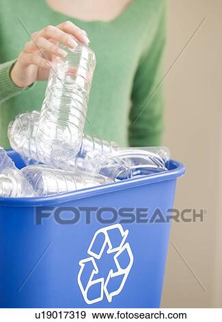 Stock Photo - Woman filling recycling bin. Fotosearch