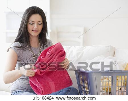 Picture - Woman folding laundry. Fotosearch