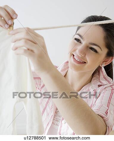 Woman hanging laundry on clothes line View Large Photo Image Stock Image - Woman hanging laundry on clothes line. Fotosearch