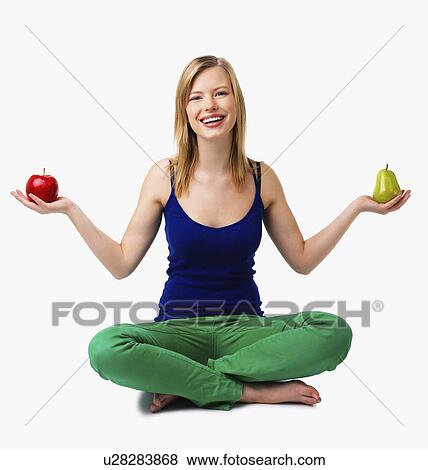 Stock Photo - Woman holding apple and pear in hands. Fotosearch