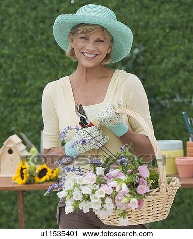 Woman holding basket of fresh cut flowers View Large Photo Image Stock Image - Woman holding basket of fresh cut flowers. Fotosearch