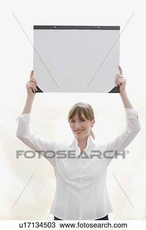 Woman holding desk blotter over head View Large Photo Image Stock Image - Woman holding desk blotter over head. Fotosearch