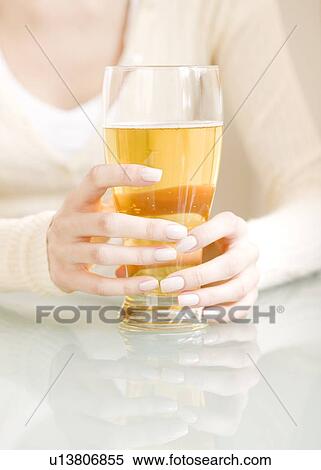 Stock Photography - Woman holding glass of beer. Fotosearch