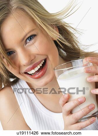 Stock Photograph - Woman holding glass of milk. Fotosearch