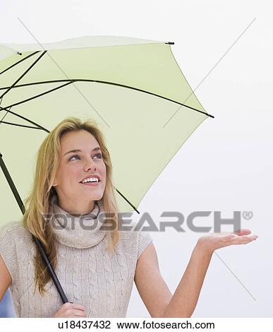 Woman holding hand out from under umbrella View Large Photo Image Stock Image - Woman holding hand out from under umbrella. Fotosearch