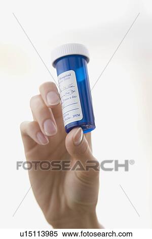 Stock Photography - Woman holding medication bottle. Fotosearch