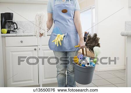 Woman holding mop and cleaning supplies View Large Photo Image Stock Photograph - Woman holding mop and cleaning supplies. Fotosearch