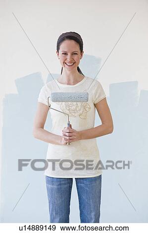 Stock Photo - Woman holding paint roller. Fotosearch