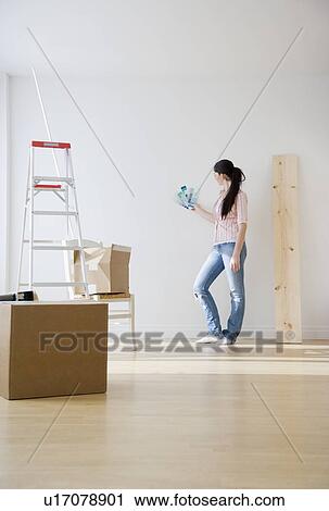 Woman holding paint swatches up to wall View Large Photo Image Stock Image - Woman holding paint swatches up to wall. Fotosearch