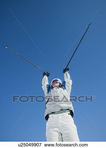 Woman holding ski poles over head View Large Photo Image Stock Photo - Woman holding ski poles over head. Fotosearch