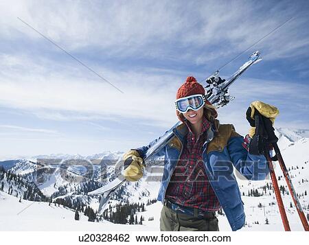Woman holding skis on shoulder View Large Photo Image Stock Image - Woman holding skis on shoulder. Fotosearch