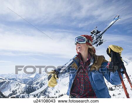 Woman holding skis on shoulder View Large Photo Image Stock Image - Woman holding skis on shoulder. Fotosearch