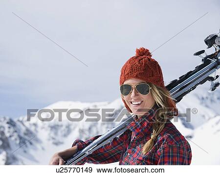 Stock Photo - Woman holding skis on shoulder. Fotosearch